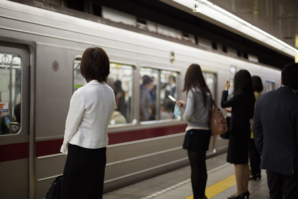 Japanese women waiting for their train on a subway platform in Tokyo.